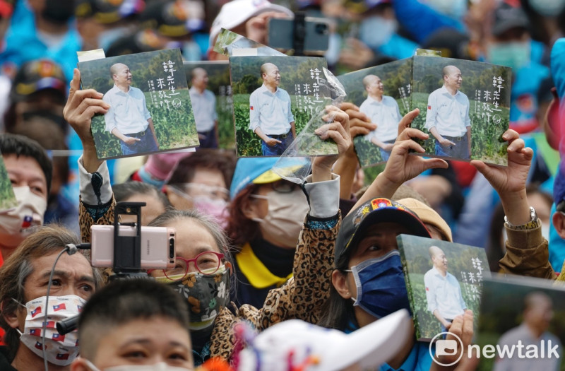 韓國瑜支持者們向台上的韓國瑜高舉他的新書。   圖：張良一/攝