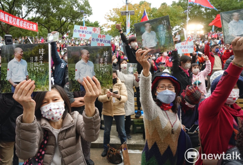 現場近萬名韓粉向韓國瑜展示他們新買的「韓先生來敲門」新書。   圖：張良一/攝