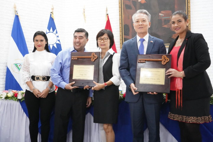 駐尼加拉瓜前大使吳進木夫婦（右2、3）接受尼京市長Reyna Rueda（右1）及副市長Enrique Armas（左2）共同頒授市鑰及榮譽市民證，尼京市議會秘書Jennifer Porras（左1）在場見證   圖：擷取自僑委會網站
