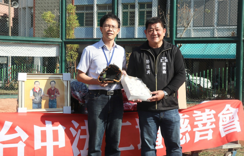 郭進興(右)捐贈母校鼓山國中棒球物資。   圖：高雄市教育局提供