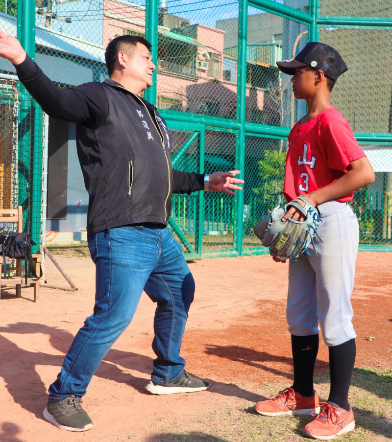 郭進興(左)現場指導小學弟投球動作。   圖：高雄市教育局提供