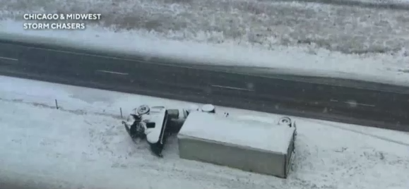 美國多州出現暴風雪，因積雪路滑一輛貨櫃車倒在公路旁邊。   圖 : 翻攝自Chicago & Midewst Stormchasers 