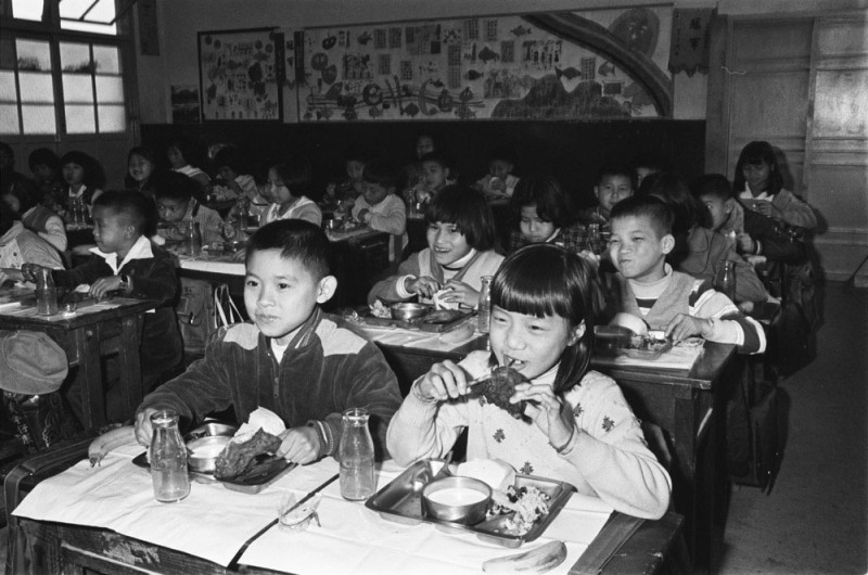 1982年學童營養午餐喝牛奶的檔案影像，見證台灣人飲食選擇趨向多元。   圖：國家發展委員會檔案管理局提供
