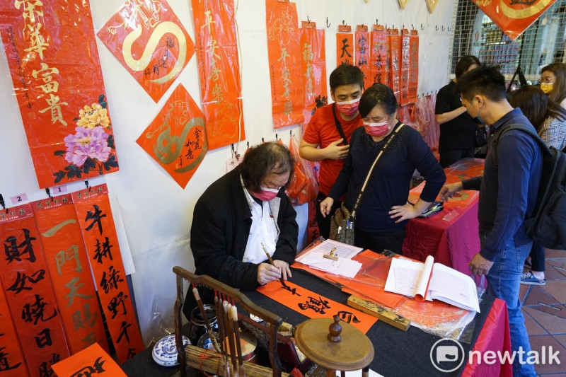 民眾挑選春聯，讓冷清的年貨大街稍有過年的節慶氣氛。   圖：張良一/攝