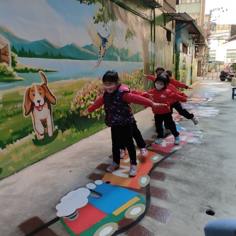 過去住宅後巷的防火空間常易被違建占據，後巷美化成為遊戲空間。   圖：新北市水利局提供