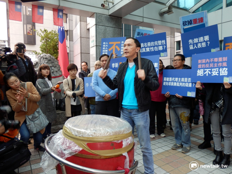 台北市議員李新17日在國民黨外擊鼓，象徵打破不公體制。   圖：符芳碩/攝