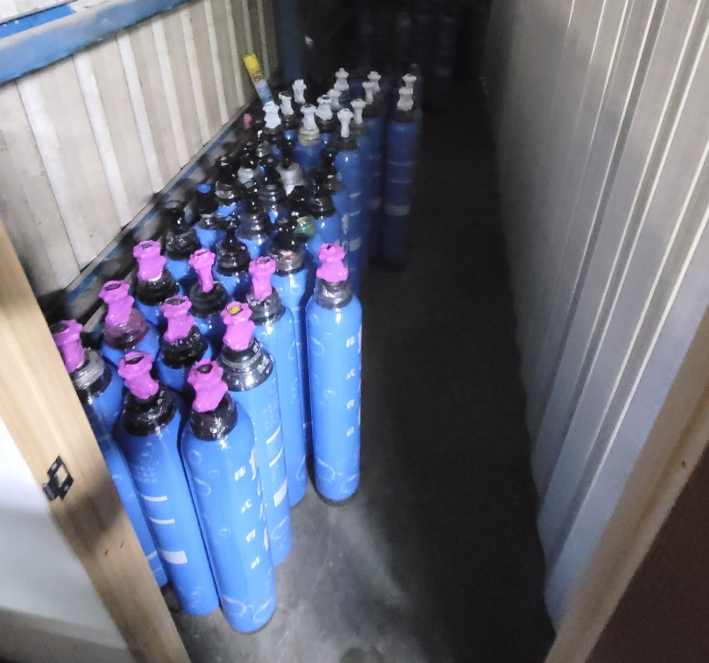 倉庫內查獲大量已包裝好待出貨的笑氣鋼瓶。   圖：新北市環保局提供