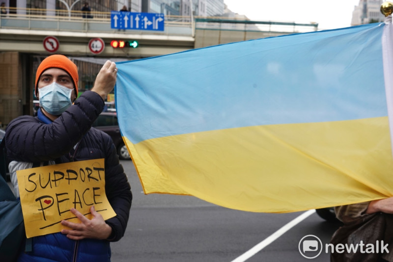 一位旅台烏克蘭人在莫北協駐台代表處外高舉烏克蘭國旗。   圖：張良一/攝