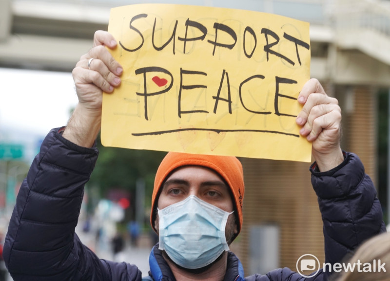 一位旅台斯拉夫人高舉「支持和平」的標語，反對俄羅斯對烏克蘭的軍事入侵。   圖：張良一/攝
