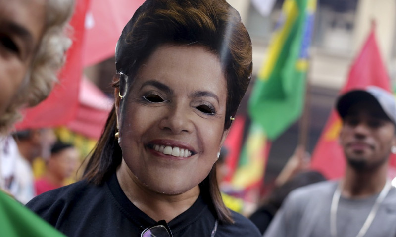巴西全國各地數萬民眾3/31拿著執政勞工黨的紅旗湧上街頭，反對彈劾總統羅賽芙。 圖為巴西民眾戴著羅賽芙的面具表達訴求。   圖：達志影像/路透社