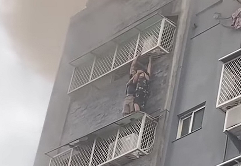 有民眾受不了高溫，吊掛在室外遮雨棚等待救援，畫面怵目驚心。   圖：翻攝自記者爆料網臉書