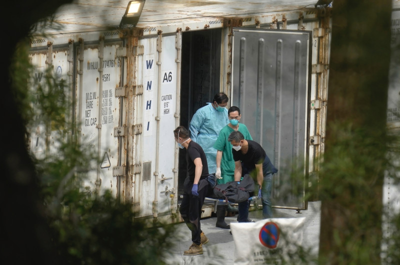 6日，香港沙田富山公眾殮屍房，工作人員將確診者屍體從冷藏貨櫃中搬移上靈車。   圖：達志影像/美聯社