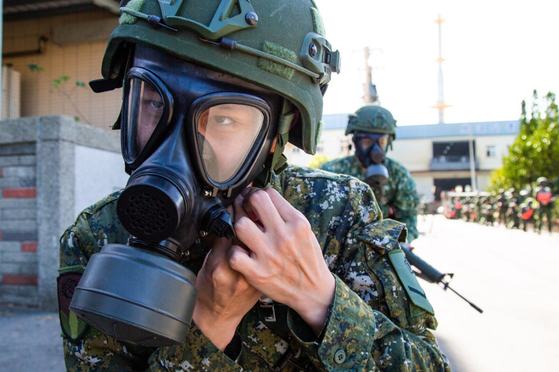 行軍過程中，召員依連長下達演練課目進行遭遇毒氣狀況處置。   圖：軍聞社提供