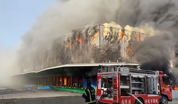 今(14)日上午7時33分，家樂福楊梅物流中心倉庫發生火警，廠房全面燃燒，濃農黑煙直竄天際。   圖：記者爆料網