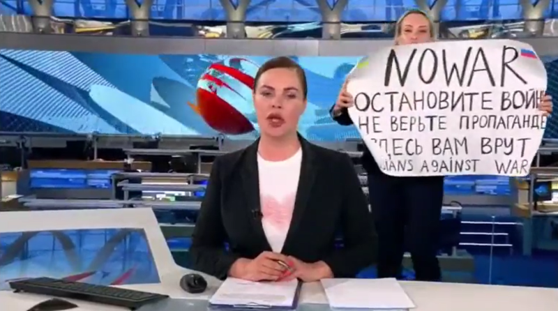 俄官媒編輯（右）在播報期間闖入高舉反戰標語遭逮捕，能會遭俄國當局重判15年。   圖：翻攝推特