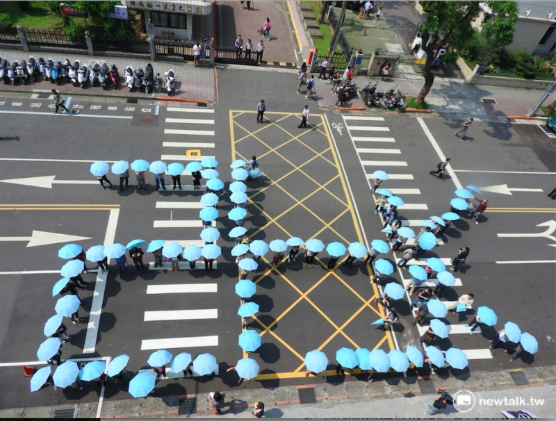 五一勞動節前夕，台灣勞工陣線與時代力量一同號召百位志工在立院前，用人體排字方式排出「26K」，呼籲政府應該重視基本工資法制化及提高勞工基本工資。   圖：鄭佑漢/攝