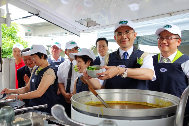 台南市副市長曾旭正穿上圍裙體驗行動餐車，烹煮熱食給與會人員享用，回顧救災行動。   圖：黃博郎/攝