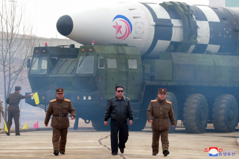 北韓領導人金正恩（黑衣人） 戴黑色墨鏡，身穿黑色外套親臨試射現場。   圖：翻攝自朝中社