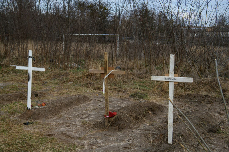 布查（Bucha）可見有平民屍體的墳墓。根據當地居民表示，這些平民被俄羅斯士兵殺害，而十字架上的銘文寫著「未知」。   圖：達志影像/路透社