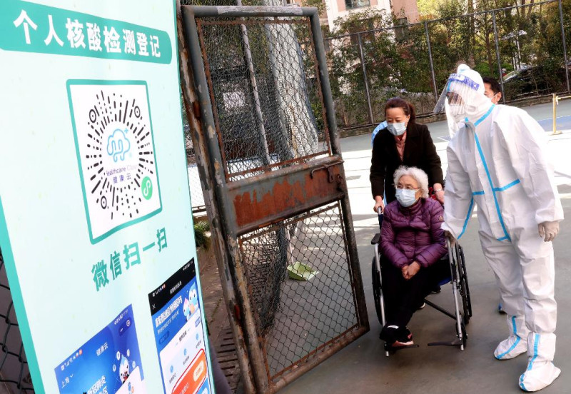 上海確診人數遽增，中國動用35000檢驗人員，拚單日篩檢全上海2500萬人。圖為行動不便老人也依規定排隊篩檢。   圖：翻攝新華社
