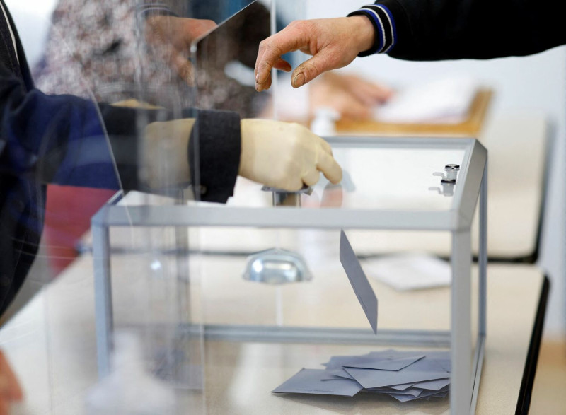 一名選民在法國的一處投票站投票，參加 2022 年法國總統大選第一輪投票。   圖：達志影像/路透社