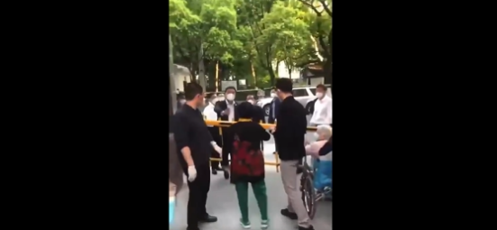 一名身穿紅衣的女性上前怒斥中國上海市委書記李強。   圖：翻攝自LQ0068推特