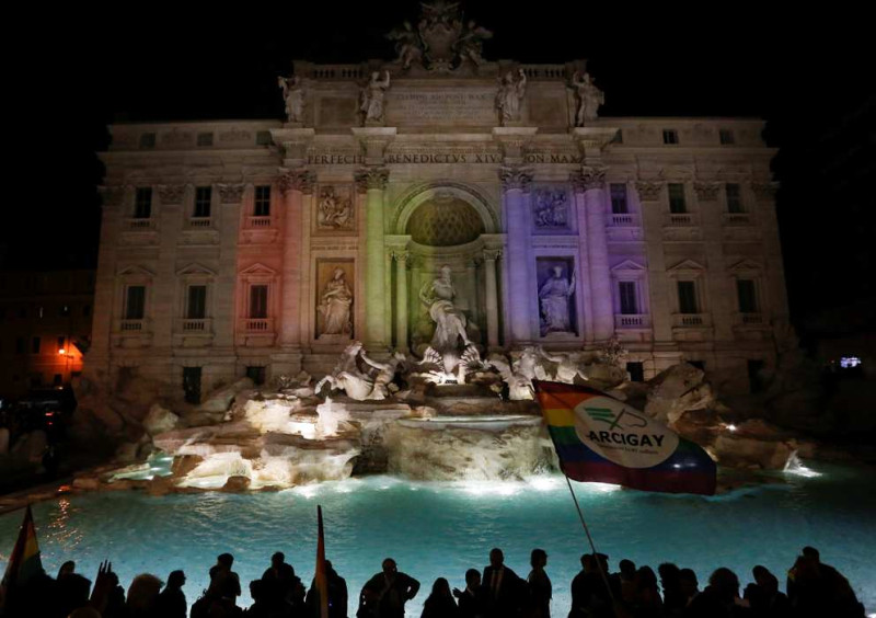 義大利為了慶祝5月11日同志民事結合法案通過，支持群眾高舉彩虹旗，彩虹燈光投射在羅馬的特雷維噴泉（Trevi Fountain）。   圖：達志影像/路透社
