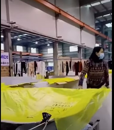 上海一大型倉儲式方艙醫院內，因漏雨使患者不得不在隔間上方蓋上一塊黃色大塑膠布。   圖：翻攝自抖音zzj_0815.