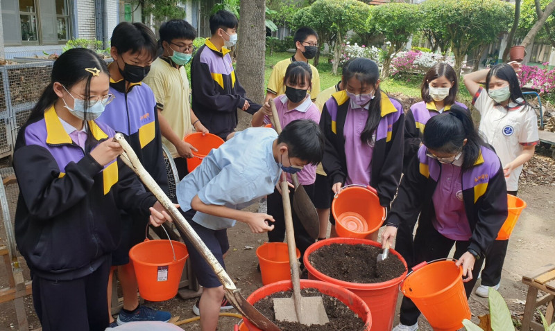 永和國中的師生在落葉堆肥場鏟土。   圖：新北市教育局提供