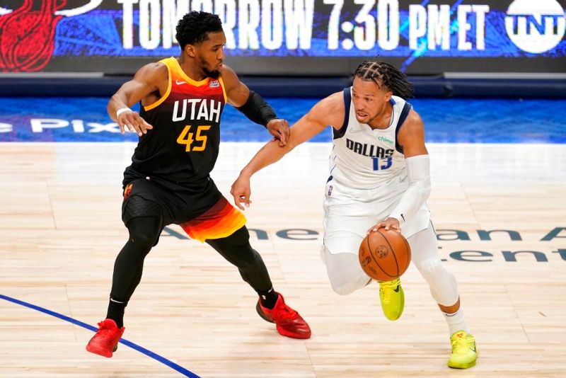 Donovan Mitchell(左)防守Jalen Brunson，後者攻下個人新高41分，率獨行俠扳平戰局。   圖／美聯社／達志影像