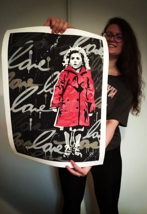 達布羅斯卡拿著朋友為她後製的《辛德勒名單》裡紅衣女孩的海報，盼這個希望之光再次閃耀。   圖：翻攝自達布羅斯卡IG