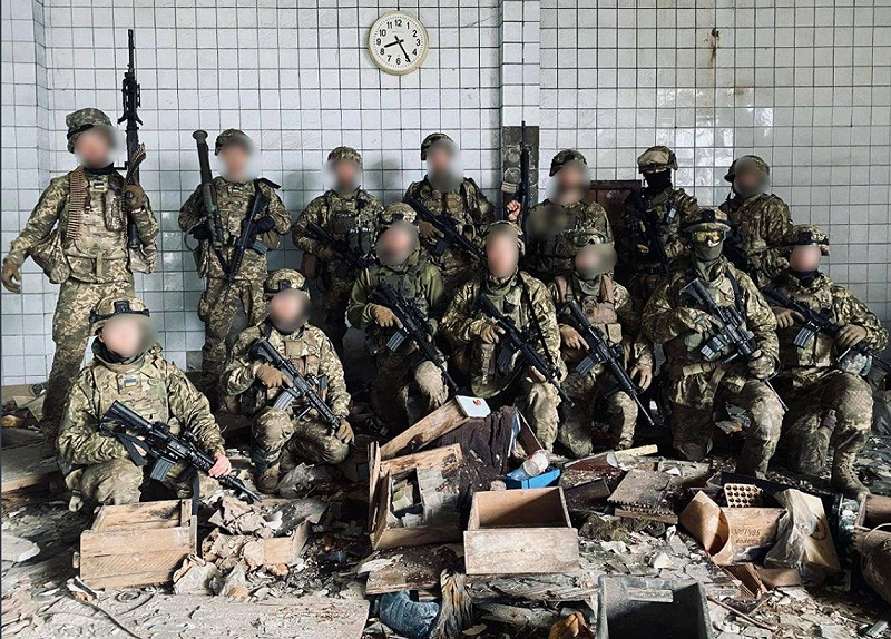 一群裝備完整的芬蘭志願軍到烏克蘭參戰，他們站在廢墟中一起合照。   圖：擷取自@rsiren2