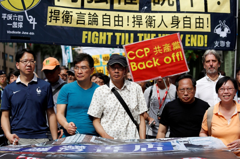 香港泛民主派18日發起「向強權說不」遊行，香港銅鑼灣書店店長林榮基(中)現身遊行起點。   圖：達志影像/路透社