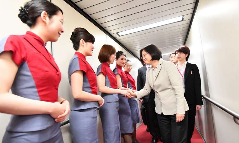 總統蔡英文24日從桃園機場搭機展開任內首度出訪行程時，向華航空服員握手致意。   圖片來源：總統府提供