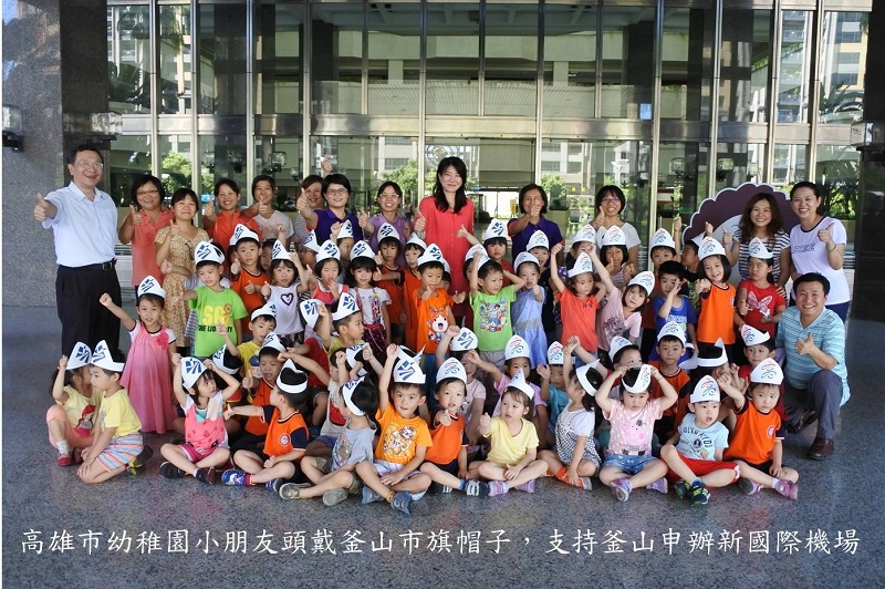 高雄市幼稚園小朋友頭戴釜山旗帽，支持釜山申請新建國際機場。   圖：高雄市政府提供