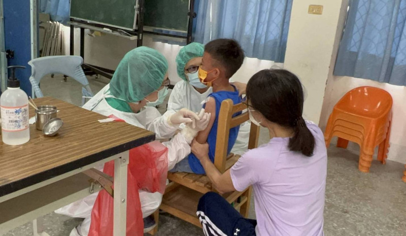 學童打疫苗時， 老師在一旁安撫情緒。   圖：屏東縣政府提供