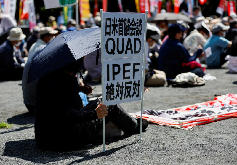 一名抗議者舉著標語，譴責美國總統拜登（Joe Biden）與日本首相岸田文雄之間的會談、美日澳印領導人四方安全對話（QUAD）峰會以及印太經濟架構。    圖：達志影像/路透社