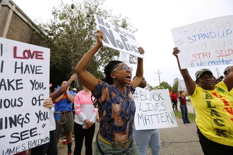 路易斯安那州的巴吞魯治（Baton Rouge）示威者，高舉標語抗議警察執法過當。   圖：達志影像/路透社