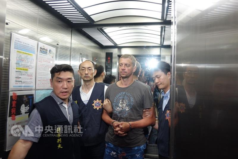 第一銀行ATM盜領案主嫌安得魯（Peregudovs Andrejs）被帶進台北市刑大。   圖片來源：中央社