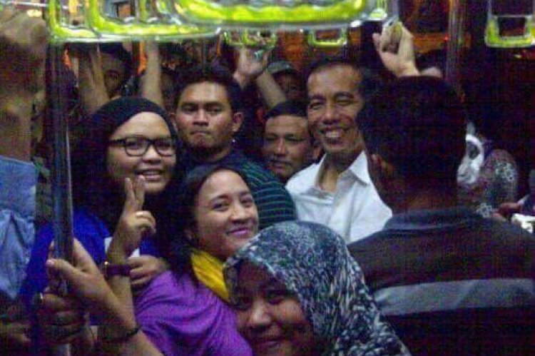 印尼總統佐科威(穿白襯衫者)以樸實親民作風深受好評，近來網路瘋傳一張他獨自搭乘公車的照片，引發熱議。   圖：翻攝網路