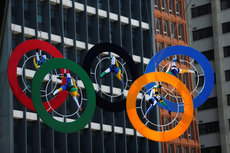 里約熱內盧奧運會的聖火24日抵達巴西聖保羅，5名特技人員在金融大樓外的奧運5環中進行表演。   圖：達志影像/路透社