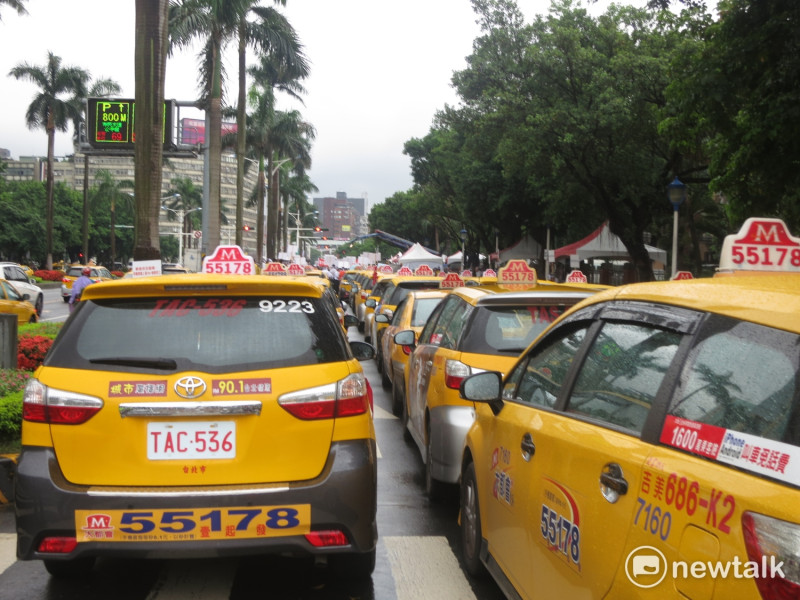 為抗議Uber，計程車司機動員上百台車輛包圍立法院。   圖：呂佳峻/攝