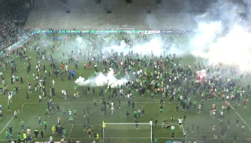 法足聯賽中，數百名聖艾蒂安球迷不滿球隊戰敗，從法甲降級，怒衝球場內投擲煙霧彈，導致多人受傷。   圖：翻攝自Twitter