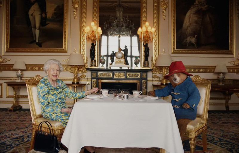 慶祝英女王歷史性統治70年，高齡96歲的女王伊莉莎白二世（左）與動畫主角柏靈頓熊，共進下午茶。   圖：翻攝自英國皇室臉書