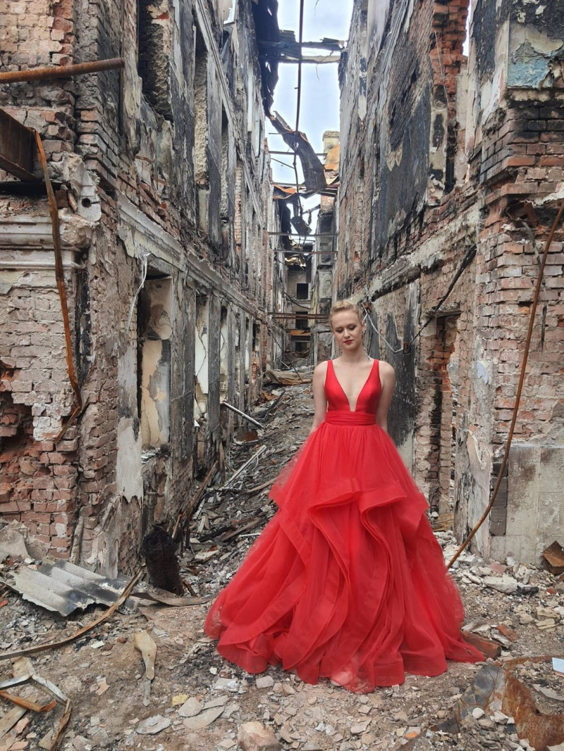 烏克蘭畢業生穿著紅色禮服，站在學校廢墟上。   圖：擷取自Hlib Vyshlinsky推特