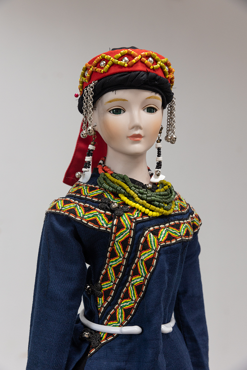 身著華麗傳統服飾、頸掛琉璃珠、頭戴族帽的排灣族娃娃。   圖：新北市原民局提供