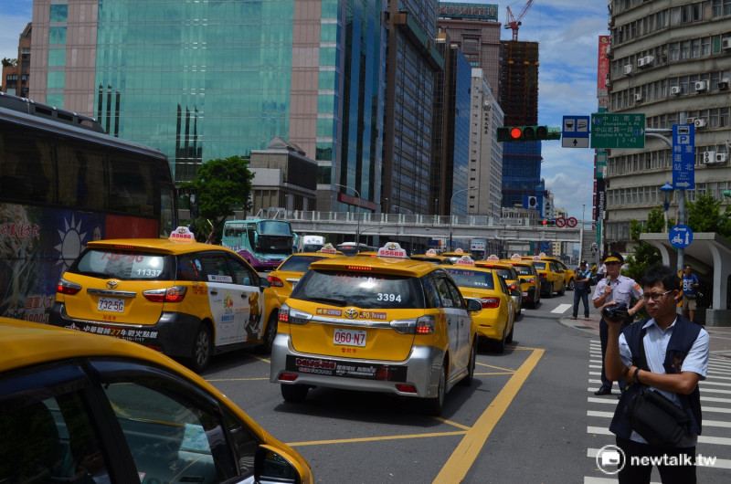上百輛計程車12日上午包圍行政院，抗議政府暫緩Uber撤資案。   圖：柯昱安/攝