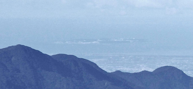 玉山氣象站人員李正紀拍攝從玉山看小琉球（遠方島嶼）的照片，引起熱議。   圖：翻攝自鄭明典臉書/李正紀攝