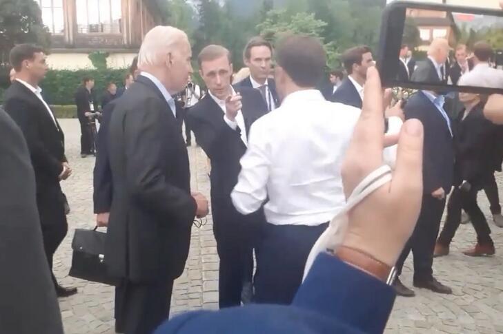 美國總統拜登（Joe Biden）正與法國總統馬克宏（Emmanuel Macron）討論能源問題，隨即被助理打斷。   圖：擷取自環球網