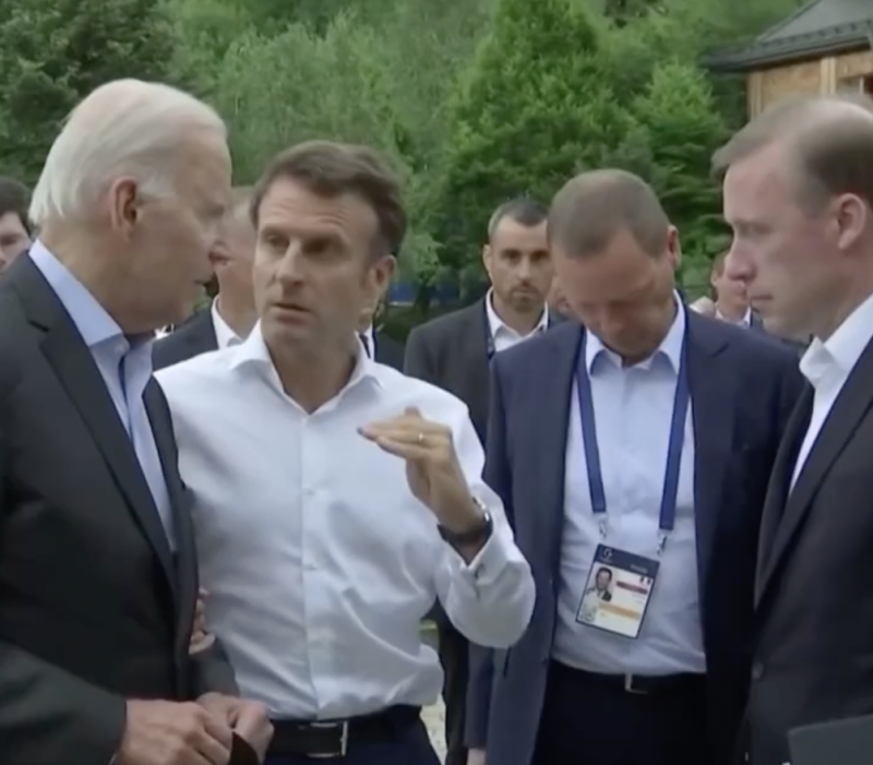 美國總統拜登（Joe Biden）正與法國總統馬克宏（Emmanuel Macron）討論能源問題，隨即被助理打斷。   圖：擷取自環球網